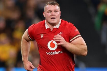 Wales rugby captain Dewi Lake looks dejected on the field after a late defeat against Scotland in the Six Nations, with teammates around him.