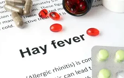 Person suffering from hay fever symptoms like sneezing and watery eyes outdoors