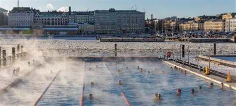 Person ice bathing in a frozen Finnish lake near a wooden sauna