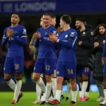 Chelsea players celebrating during a Premier League match amid club fine investigation.