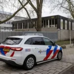 Police and firefighters outside a Jewish school building in Amsterdam after an explosion damaged the outer wall.