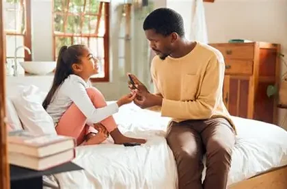 Father helping child manage diabetes using a mobile app