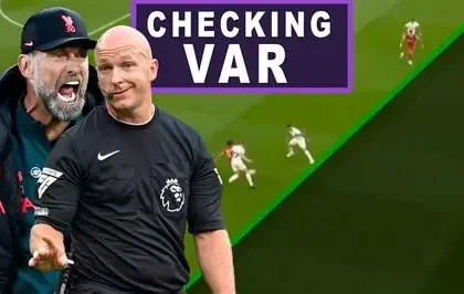 Football referee consulting VAR during a Premier League match