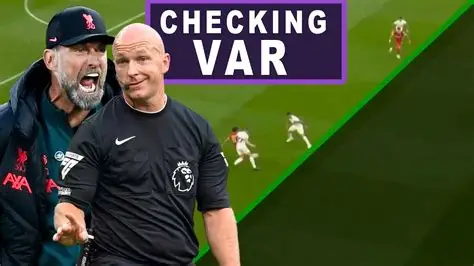 Football referee consulting VAR during a Premier League match