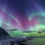 Bright green Northern Lights dancing across a dark Arctic sky