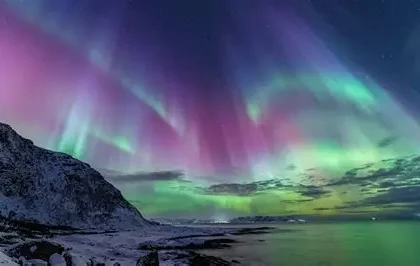 Bright green Northern Lights dancing across a dark Arctic sky