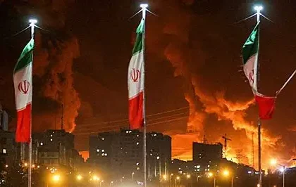 Man raising Iranian flag amid rubble after air strikes in Tehran