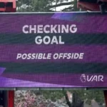 VAR decision being reviewed during a Premier League match with players waiting