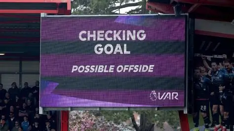 VAR decision being reviewed during a Premier League match with players waiting