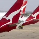 Qantas aircraft parked at an airport amid refund settlement news