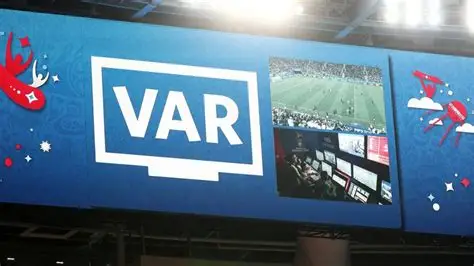 Football referee reviewing VAR decision during a match in European league