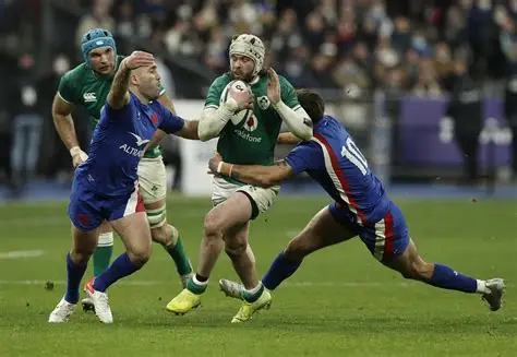 France rugby players celebrating a Six Nations victory after a tough tournament.