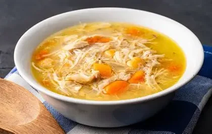 Traditional healing broth with vegetables and herbs served in a bowl