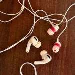 Person listening to music using wired headphones connected to a smartphone.