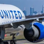 United Airlines passenger dons headphones on flight while neighbor glares at phone audio blasting without courtesy.