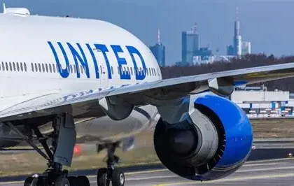 United Airlines passenger dons headphones on flight while neighbor glares at phone audio blasting without courtesy.