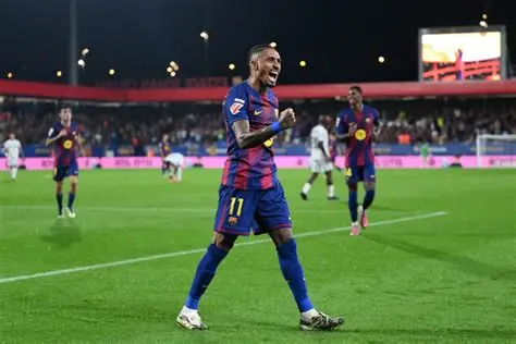 Barcelona's Raphinha gestures angrily post-match after Champions League defeat to Atletico Madrid amid referee controversy.