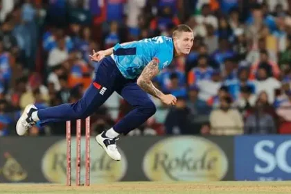 England bowler Brydon Carse grimaces holding injured right bowling hand during training session.