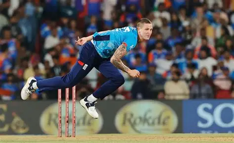 England bowler Brydon Carse grimaces holding injured right bowling hand during training session.