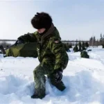 Canadian military patrol crossing Arctic terrain on snowmobiles during extreme weather conditions