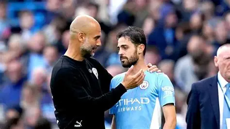Manchester City captain Bernardo Silva celebrates EFL Cup win as Pep Guardiola watches intently from touchline.