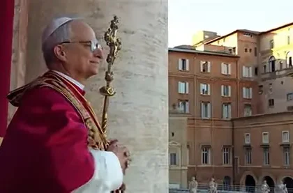 Pope Leo XIV waves from St Peter's Basilica balcony amid thousands of Easter worshippers filling Vatican square with spring flowers.