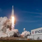 SpaceX Falcon rocket launches dramatically at night from Kennedy Space Center, trailing fire toward orbit amid starry sky.