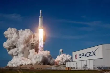 SpaceX Falcon rocket launches dramatically at night from Kennedy Space Center, trailing fire toward orbit amid starry sky.