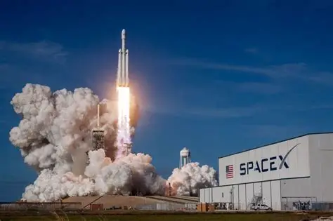 SpaceX Falcon rocket launches dramatically at night from Kennedy Space Center, trailing fire toward orbit amid starry sky.