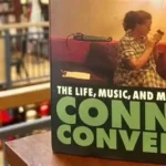 Connie Converse playing guitar in 1950s New York apartment