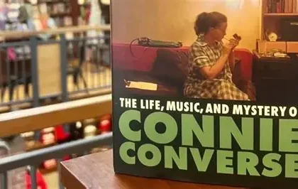 Connie Converse playing guitar in 1950s New York apartment