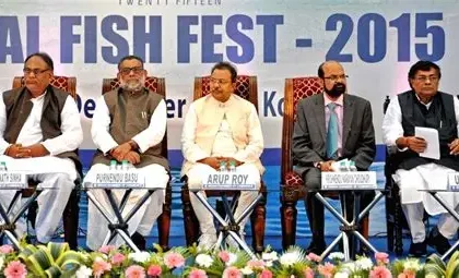 BJP candidate Rakesh Singh holds a large fish high during his West Bengal election campaign in Kolkata.