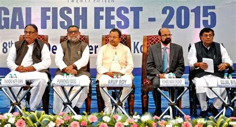 BJP candidate Rakesh Singh holds a large fish high during his West Bengal election campaign in Kolkata.