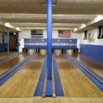 Bowlers compete in dimly lit basement alley under Immaculate Conception Catholic School Chicago