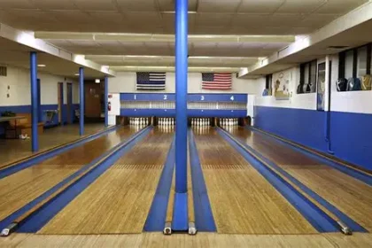 Bowlers compete in dimly lit basement alley under Immaculate Conception Catholic School Chicago