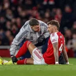 Arsenal defender Ben White reacts after suffering a knee injury during a Premier League match.