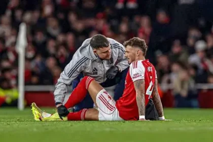Arsenal defender Ben White reacts after suffering a knee injury during a Premier League match.