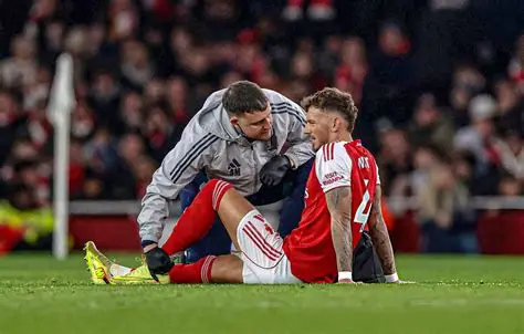 Arsenal defender Ben White reacts after suffering a knee injury during a Premier League match.