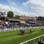 Jockeys and officials inspecting Chester racecourse after unsafe ground caused race delay