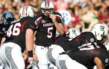 Former South Carolina Gamecocks quarterback Stephen Garcia in uniform on the sideline during a college football game, looking focused before taking the field.