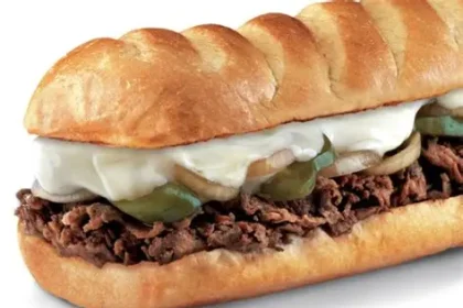 Medium Firehouse Subs Steak & Cheese Melt with prime rib, provolone, caramelized onions on top-cut roll.