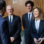 Jack Schlossberg and Caroline Kennedy pose outside a deli on Manhattan’s Upper West Side after a bagel stop.
