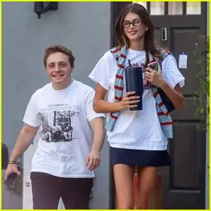 Kaia Gerber and Jake Shane carrying matching burgundy Chanel Maxi Flap bags in Beverly Hills