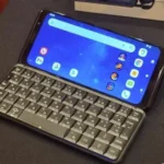 A modern smartphone with a physical keyboard displayed beside wireless touchscreen devices.