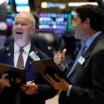 Traders monitor stock market screens as the S&P 500 reaches a record high on Wall Street.
