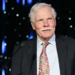 Ted Turner standing inside a CNN newsroom during the early years of the network