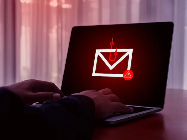 Phishing scams warning signs displayed on a laptop and smartphone screen