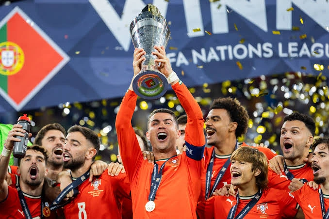 Cristiano Ronaldo celebrating with trophies won during his legendary football career